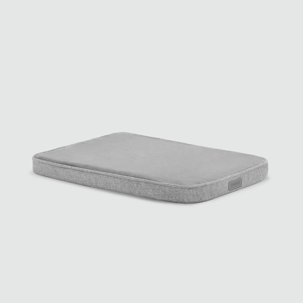 A gray mattress with no sheets on it