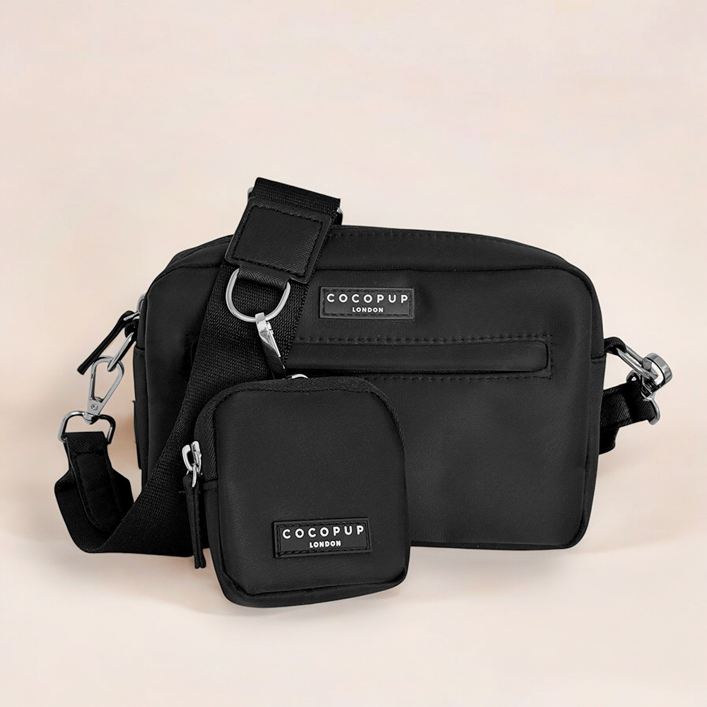 Black Cocopup London dog walking bag with matching treat pouch, displayed on a light beige background.