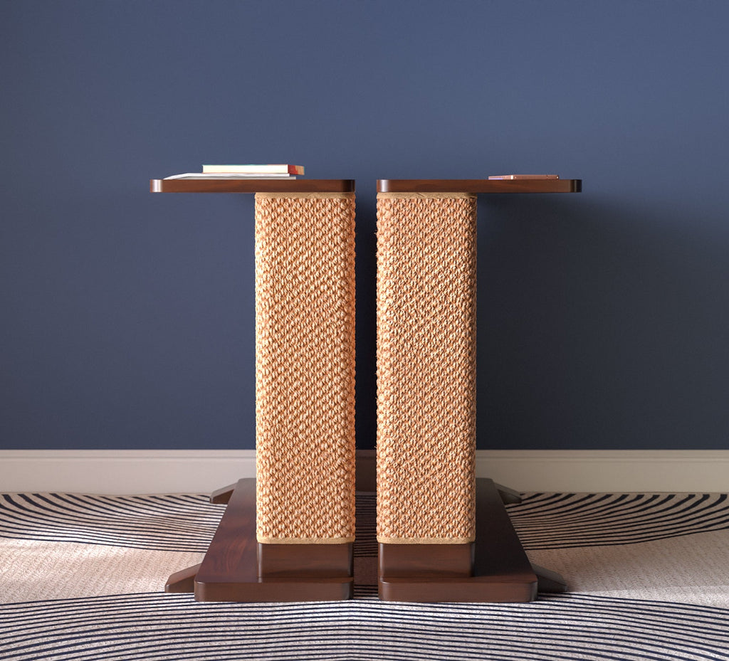 A Cat-e-Corner table placed next to a sofa, integrating a cat's scratching post with a small table, in a room with a plant and a colorful cushion.