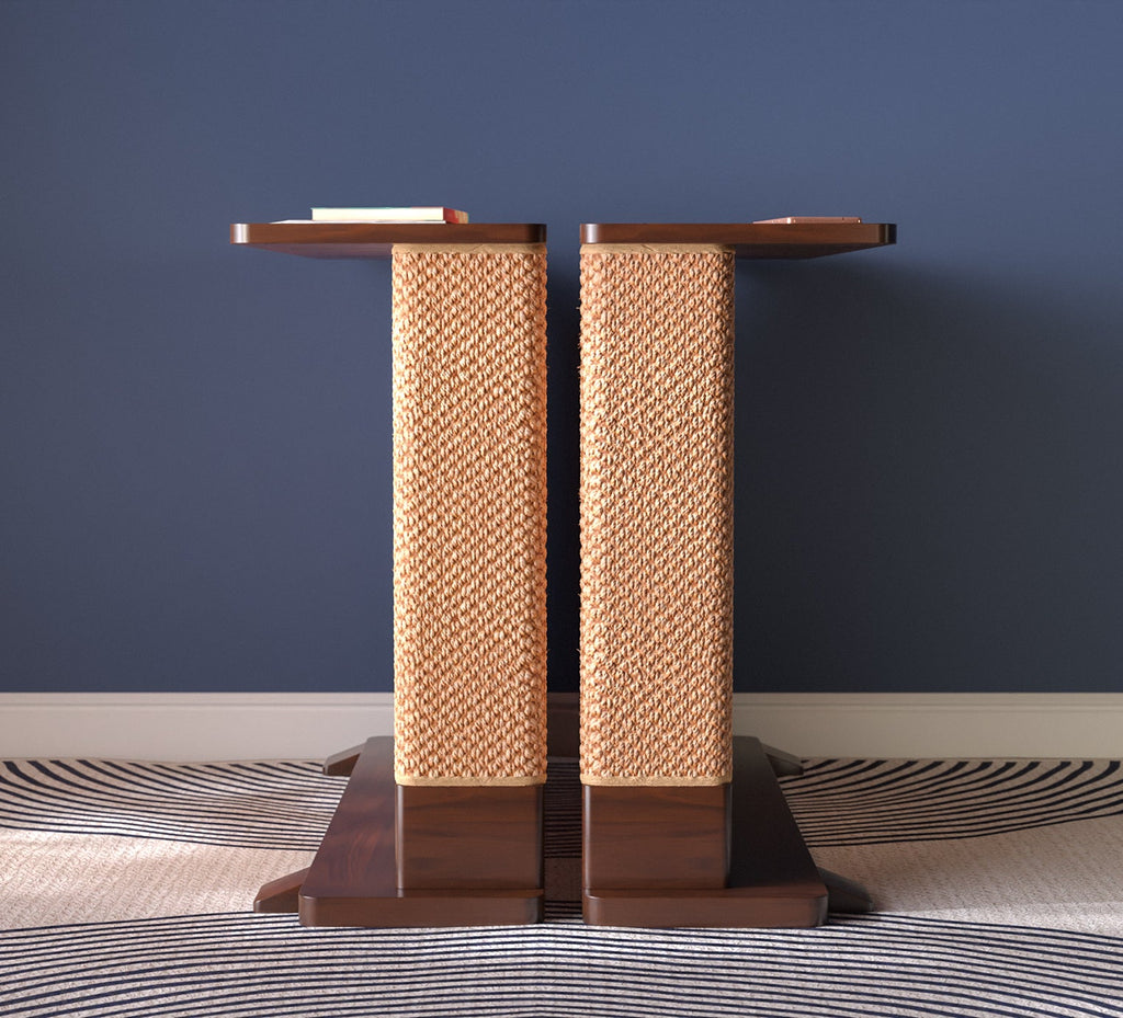 A Cat-e-Corner table placed next to a sofa, integrating a cat's scratching post with a small table, in a room with a plant and a colorful cushion.
