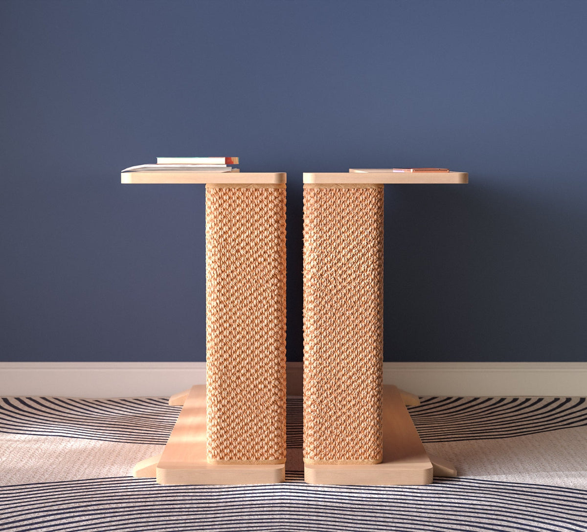 A Cat-e-Corner table placed next to a sofa, integrating a cat's scratching post with a small table, in a room with a plant and a colorful cushion.