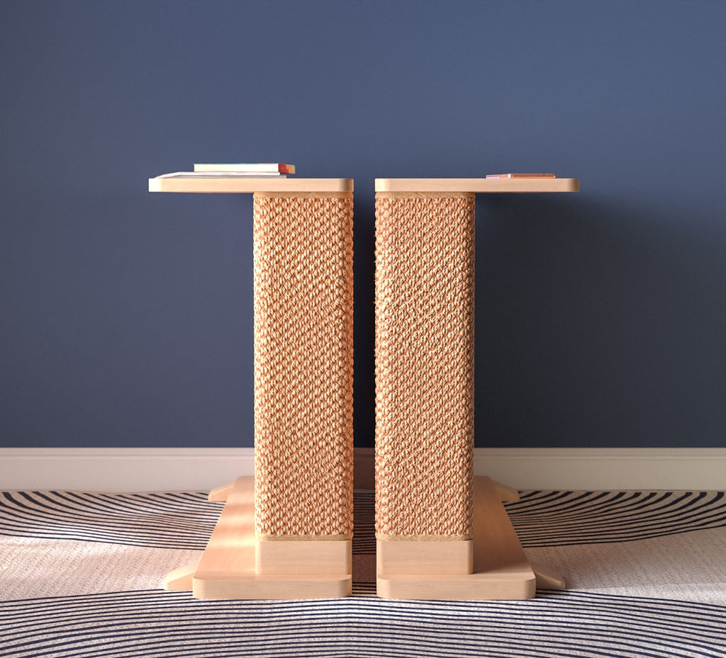 A Cat-e-Corner table placed next to a sofa, integrating a cat's scratching post with a small table, in a room with a plant and a colorful cushion.