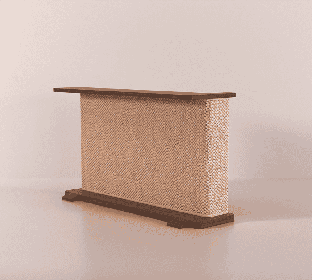 A Cat-e-Corner table placed next to a sofa, integrating a cat's scratching post with a small table, in a room with a plant and a colorful cushion.
