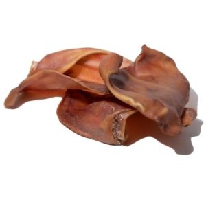 Angled view of smoked pig ears showcasing natural dried texture and curved shape on white background