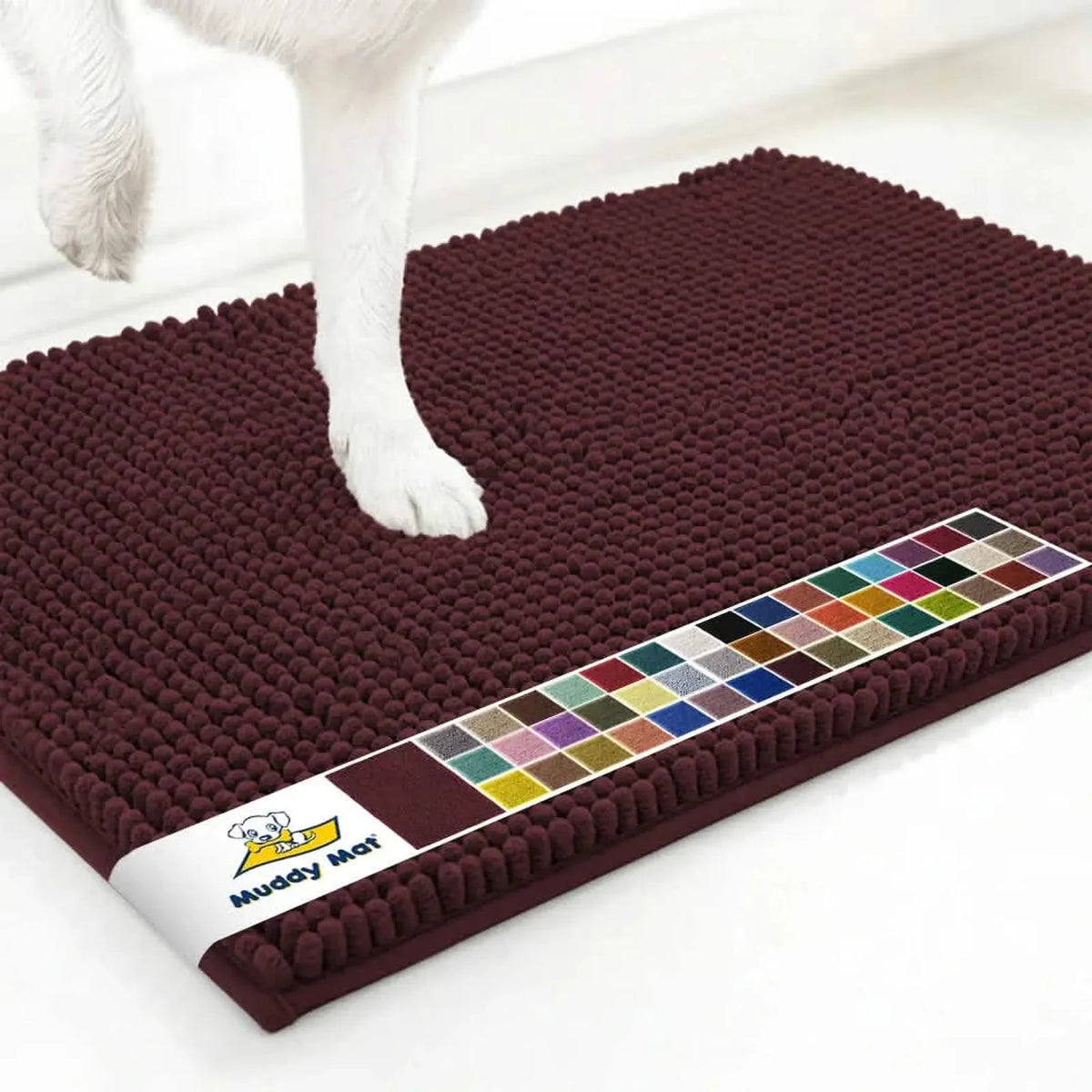 Angled close up of Muddy Mat anti-mud dog door mat in rust showing textured chenille surface and dog paw on white floor